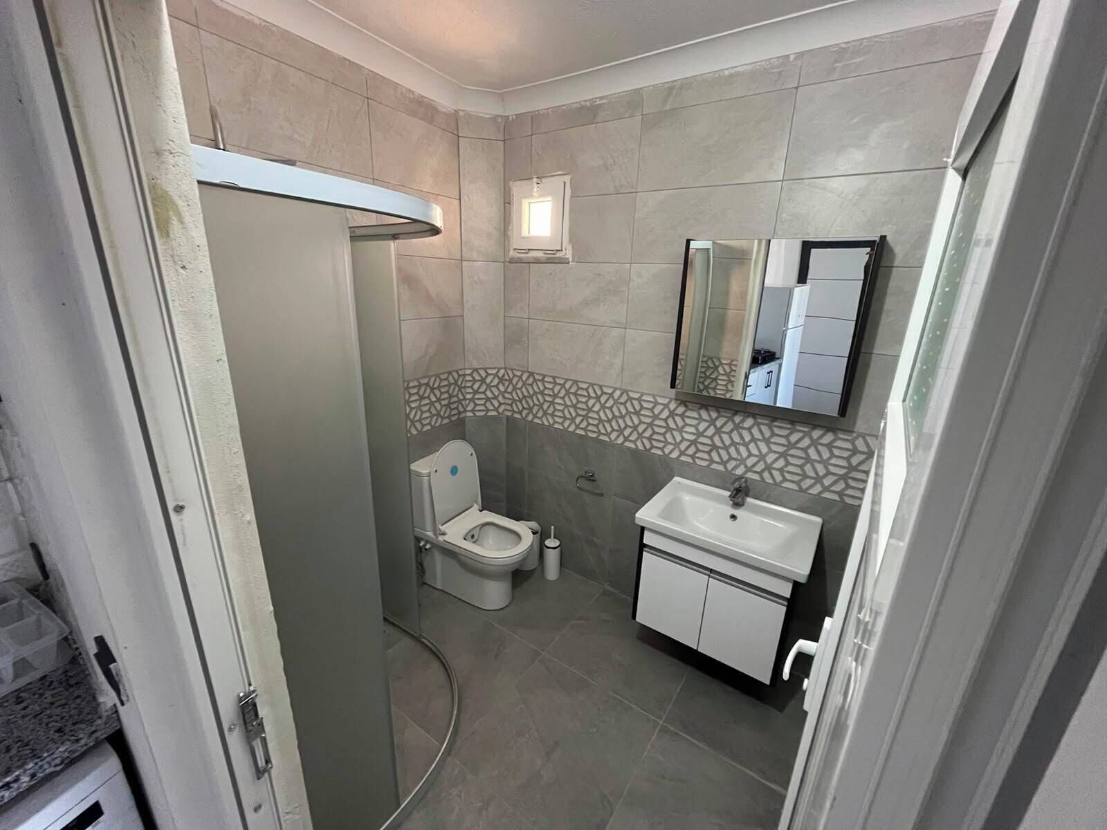 Un bagno con il water, un lavandino e uno specchio.