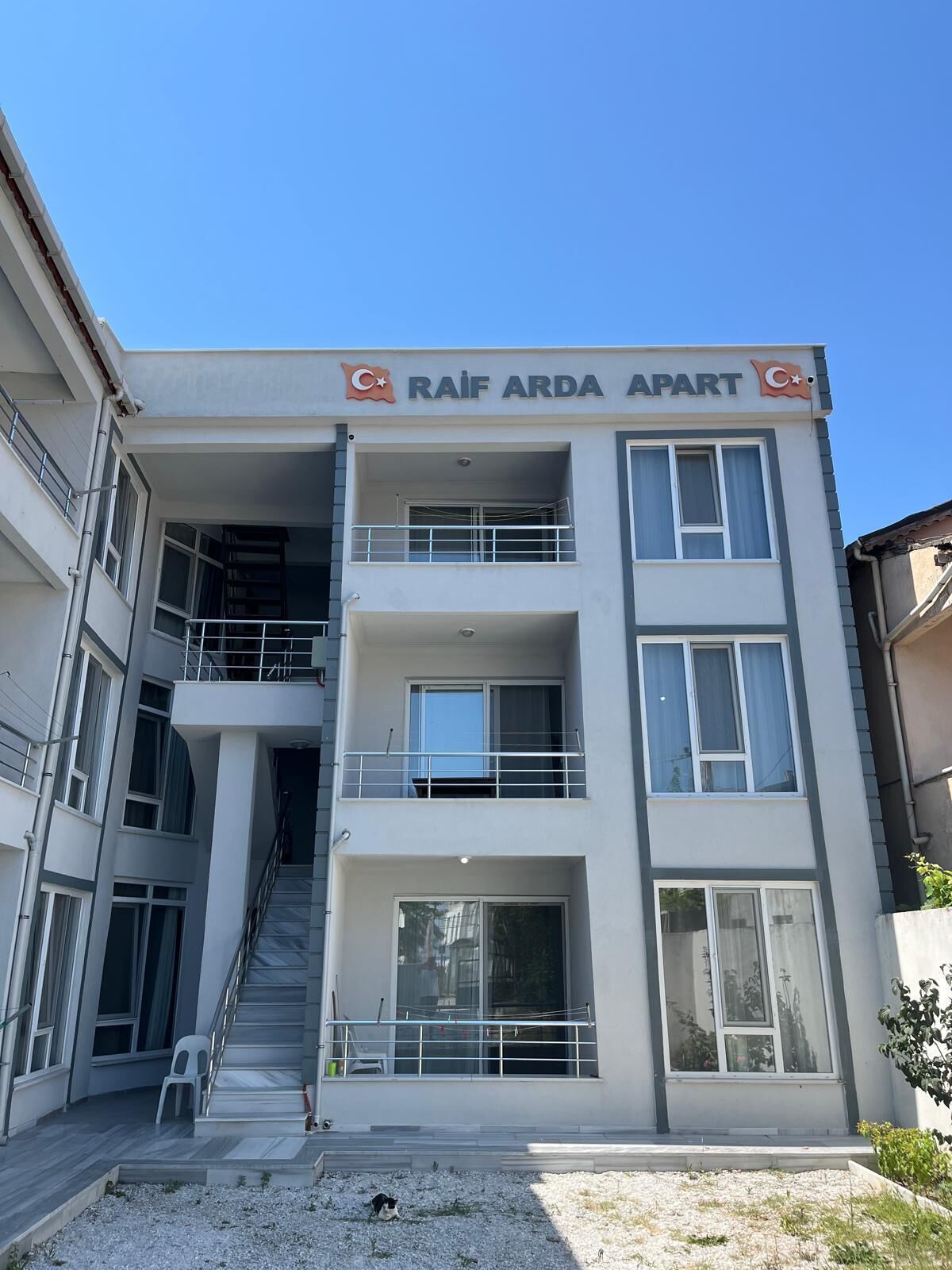 Un immeuble à plusieurs étages sur lequel on peut lire l’inscription : « RAIF ARDA APART ».
