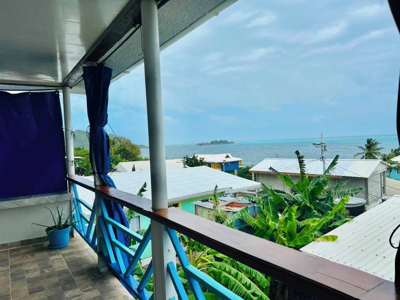 Een balkon met uitzicht op zee en gebouwen.