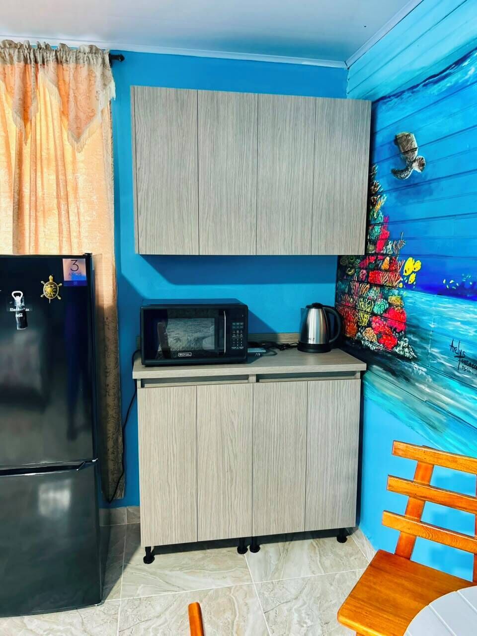 Eine kleine Küche mit Kühlschrank, Mikrowelle und Schrank.
