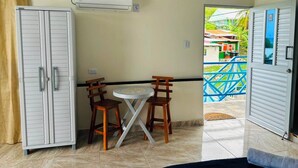 Una habitación con una mesa, sillas, un equipo de aire acondicionado y vistas al exterior.