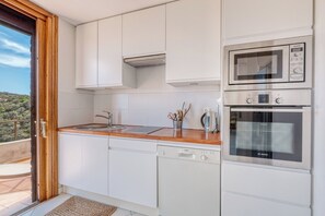 Une cuisine moderne avec des meubles blancs, un lave-vaisselle Bosch, un four Siemens et un plan de travail en bois.