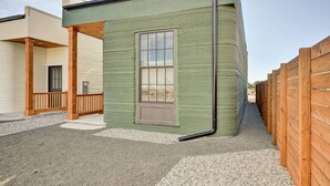 Un edificio pequeño de un solo piso, con fachada verde, una ventana y una puerta.