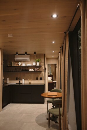 Una cocina moderna con armarios de madera, una isla central y un comedor con mesa y sillas.