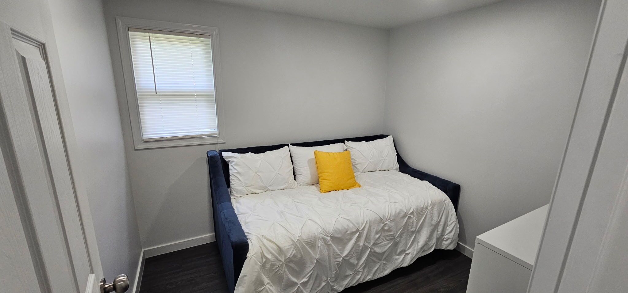 Une chambre à coucher avec un lit, une fenêtre et une porte.