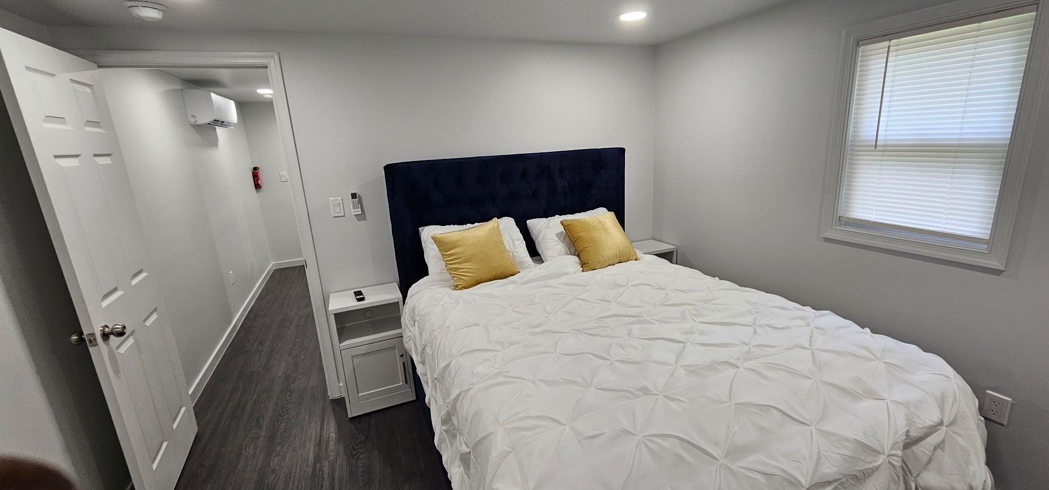 A bedroom with a bed, bedside tables, a wardrobe, and a window.