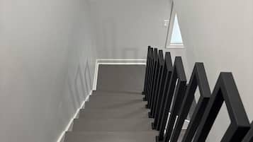 A staircase with a modern design, featuring a series of steps and black handrails.