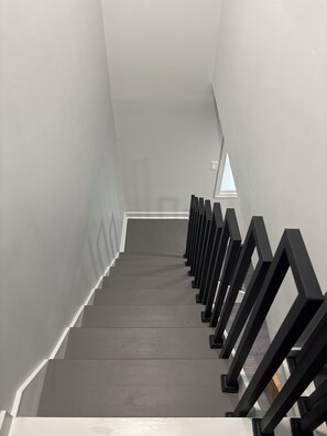 Una escala de disseny modern, amb una sèrie de graons i baranes negres.