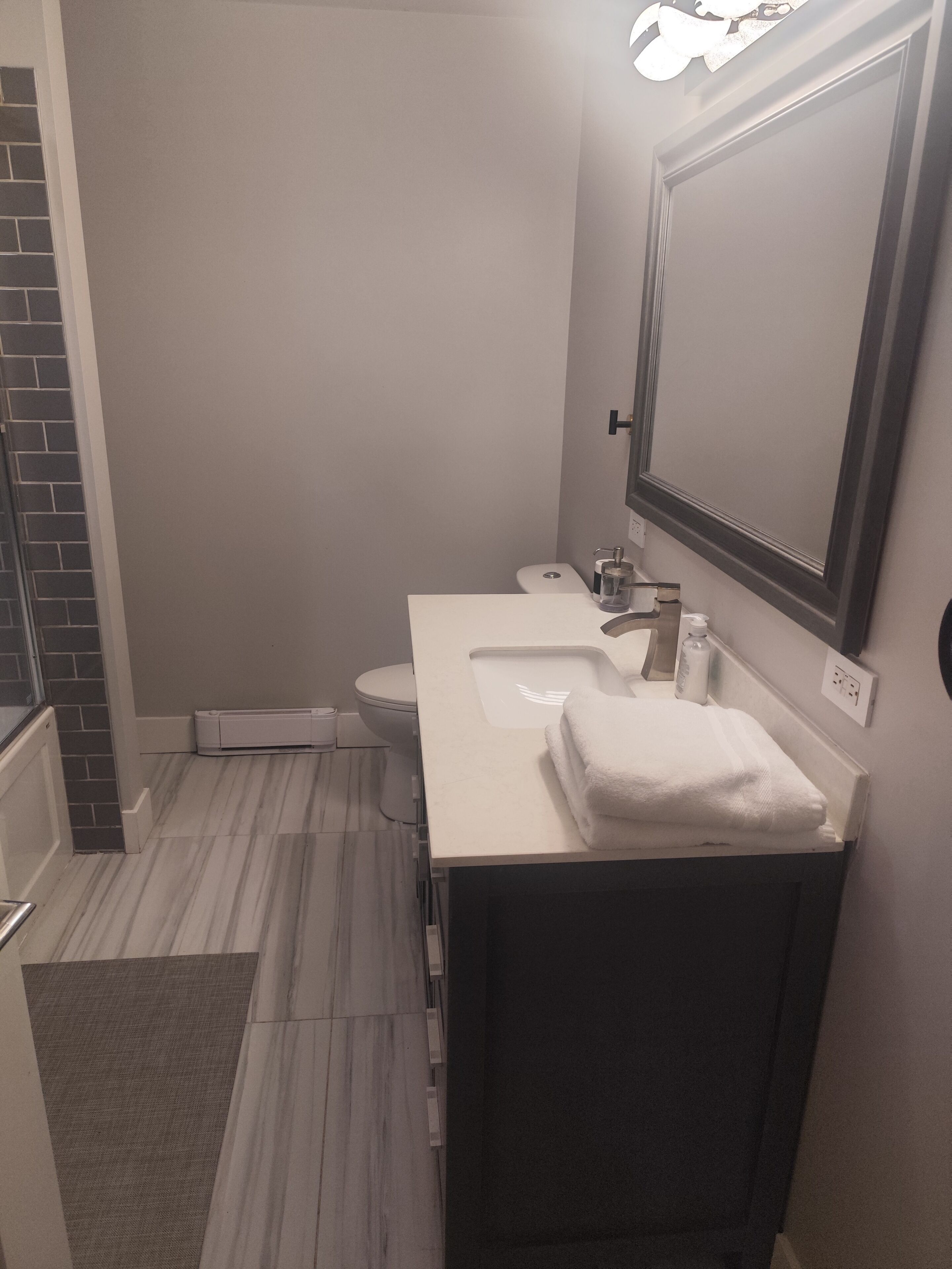 A bathroom with a white sink, a mirror, and a toilet.