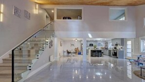 A spacious interior with a staircase, a kitchen area, and a dining space.