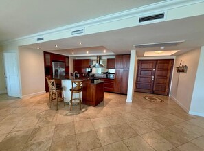 A spacious kitchen with a central island, bar stools, and a large refrigerator. - The Lighthouse, Unit 3A-Oyster Bay, St. Maarten. Walk to Beach (Oyster Bay)