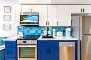 Eine moderne Küche mit Einbauofen, Geschirrspüler und Edelstahl-Kühlschrank.
