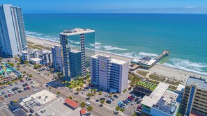 A coastal cityscape with high-rise buildings, a beach, and a pier. - Oceanfront Blue Haven at Yachtsman by Skywheel! (Myrtle Beach)