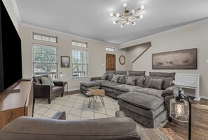 Een woonkamer met een modulaire bank, een televisie en een open haard.