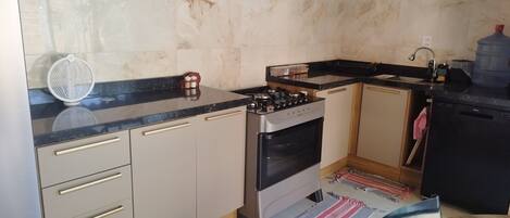 A compact kitchen with a gas stove, a built-in oven, and a sink.