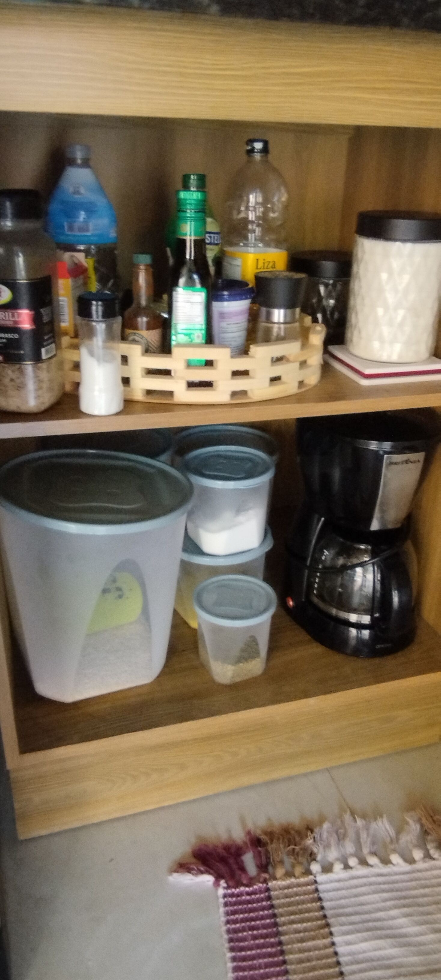 Ein Küchenregal mit verschiedenen Behältern, Flaschen und einer Kaffeemaschine.