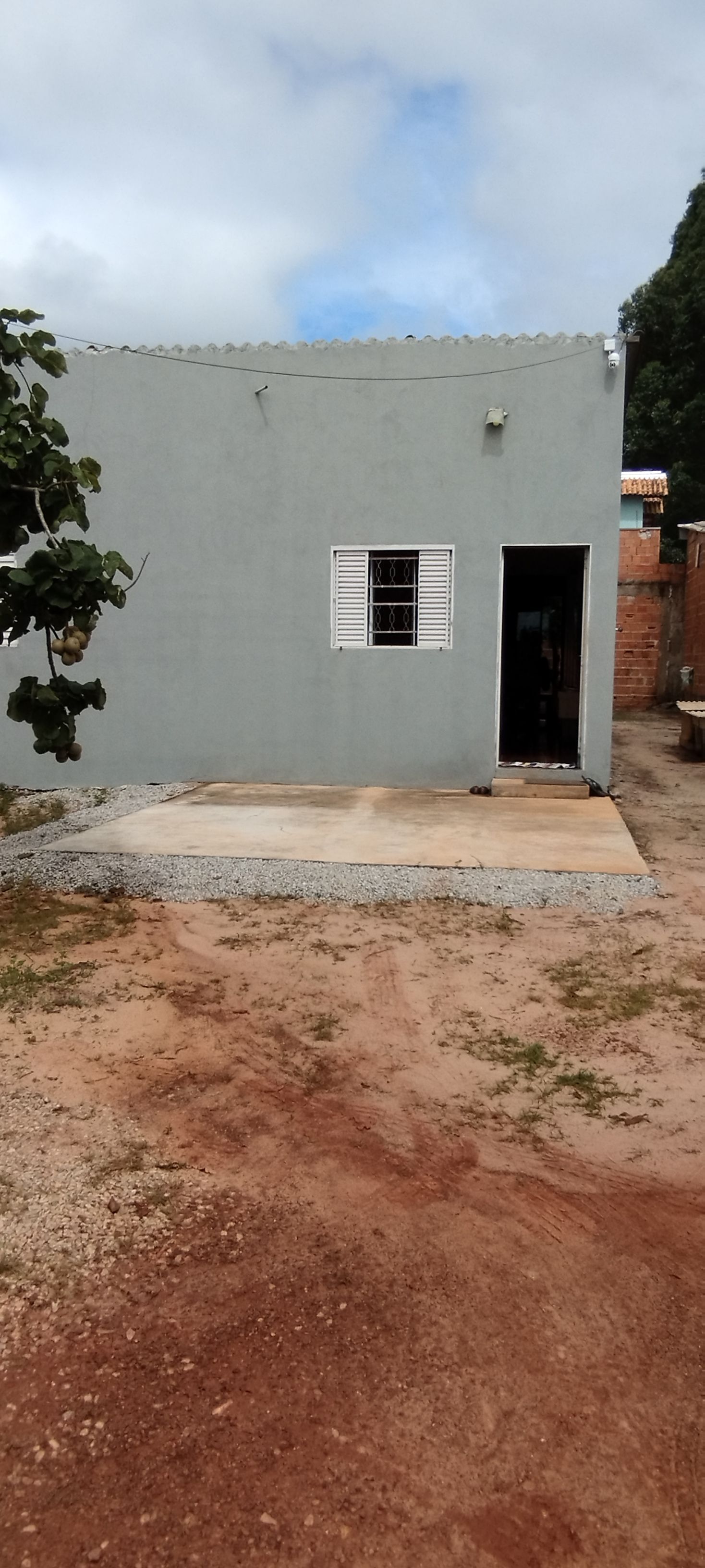 Um pequeno edifício térreo com telhado plano e uma única porta.