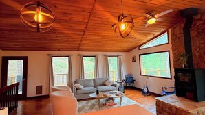 A cozy living room with a stone fireplace, a sofa, and a coffee table.