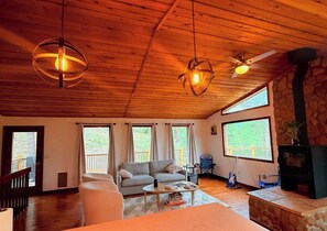 Una sala de estar acogedora con chimenea de piedra, un sofá y una mesa de centro.