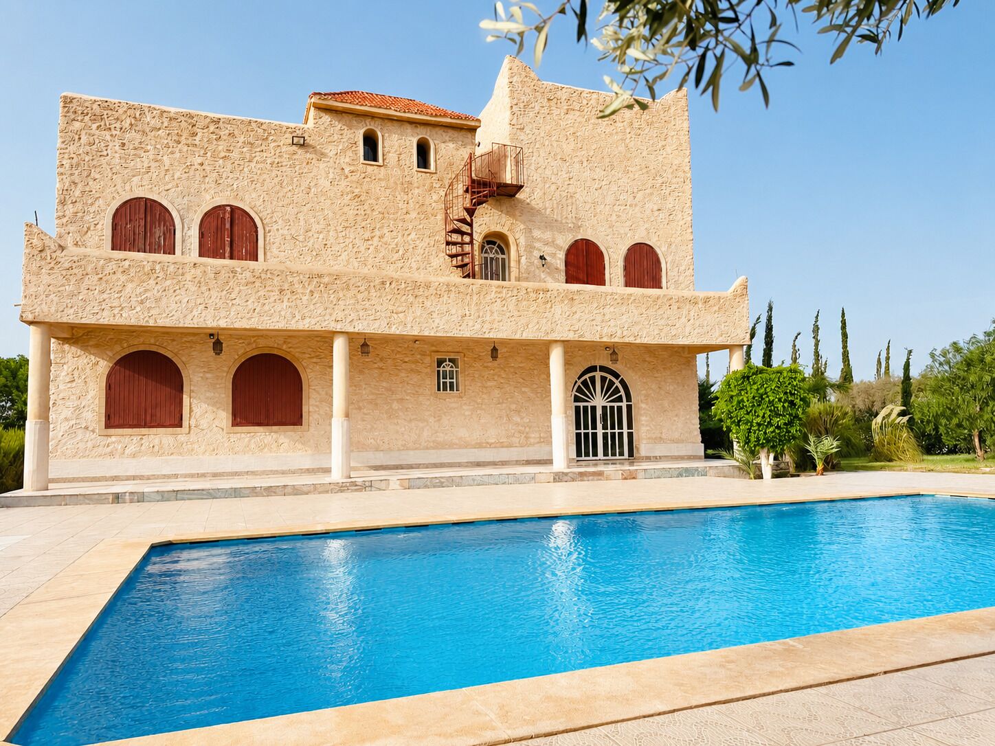 A large building with a swimming pool in front.