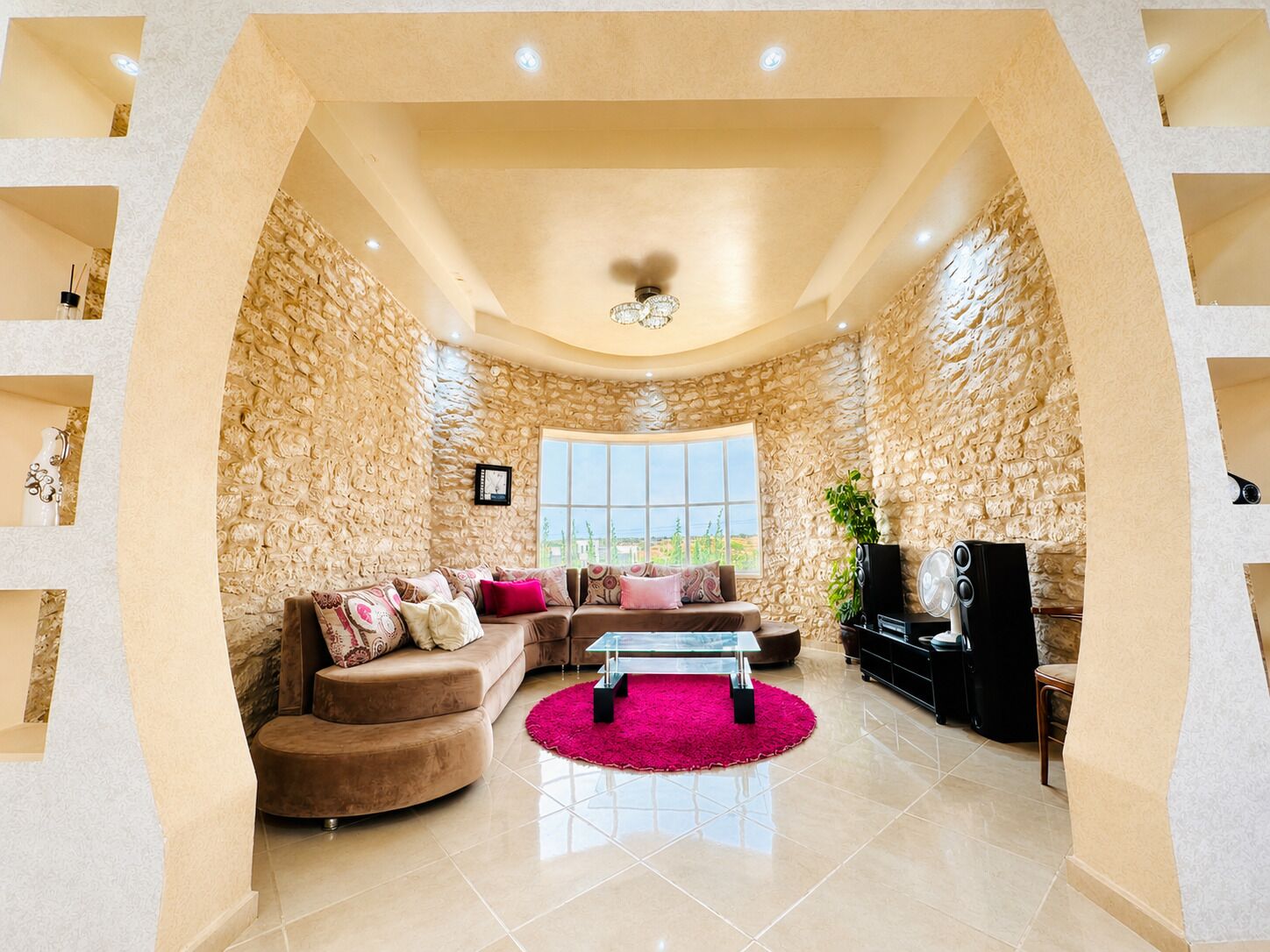 A living room with a stone wall, a sofa, a coffee table, and a TV.