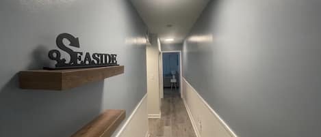 En hall med en träbänk, en skylt som sitter på väggen och en dörr längst ner.