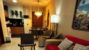 Una sala de estar con un sofá rojo, un felpudo de piel y un comedor con una araña.