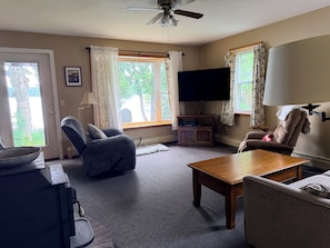 A living room with a ceiling fan, a flat-screen TV mounted on the wall, a wooden coffee table, two sofas, and a television cabinet. - Serene 3-bedroom house in charming Newark perfect for relaxing stays (Newark)