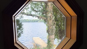 Ein sechseckiges Fenster mit Blick auf einen See und eine Anlegestelle.