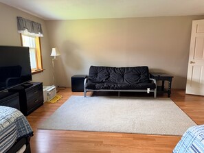 A room with a sofa, a television, a lamp, and a door. - Serene 3-bedroom house in charming Newark perfect for relaxing stays (Newark)