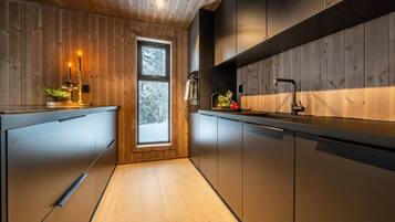 A modern kitchen with wooden walls, a window, and a sink.
