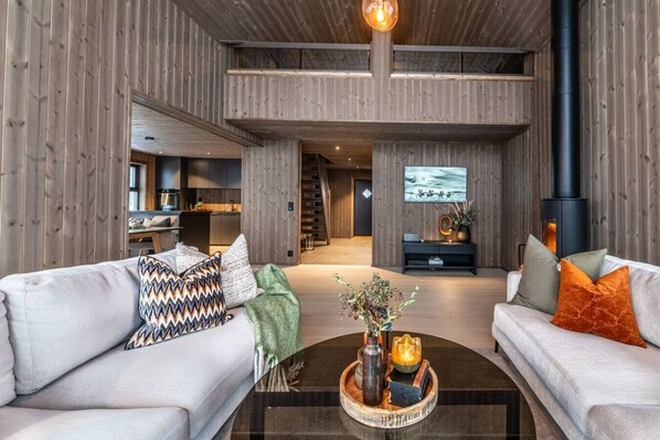A modern living room with a fireplace, sofas, and a coffee table.