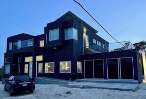 Una casa moderna de dos pisos con garaje, ventanas grandes y entrada para vehículos.