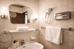A bathroom with a sink, mirror, towel rack, and a hairdryer.
