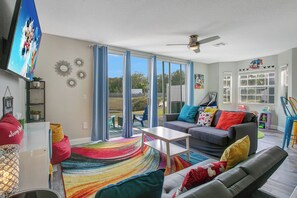 A living room with a sofa, coffee table, and a colorful rug. - Disney Area · Themed Family Home · Pool · Parking (Davenport)