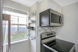 A kitchen with a built-in oven, microwave, and a window with a view. - Disney-Themed Family Home, Pool and Courts, Minutes to the Parks (Davenport)