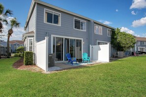 A two-story house with a covered patio area, a sliding glass door entrance, and a small lawn. - Disney Area · Themed Family Home · Pool · Parking (Davenport)