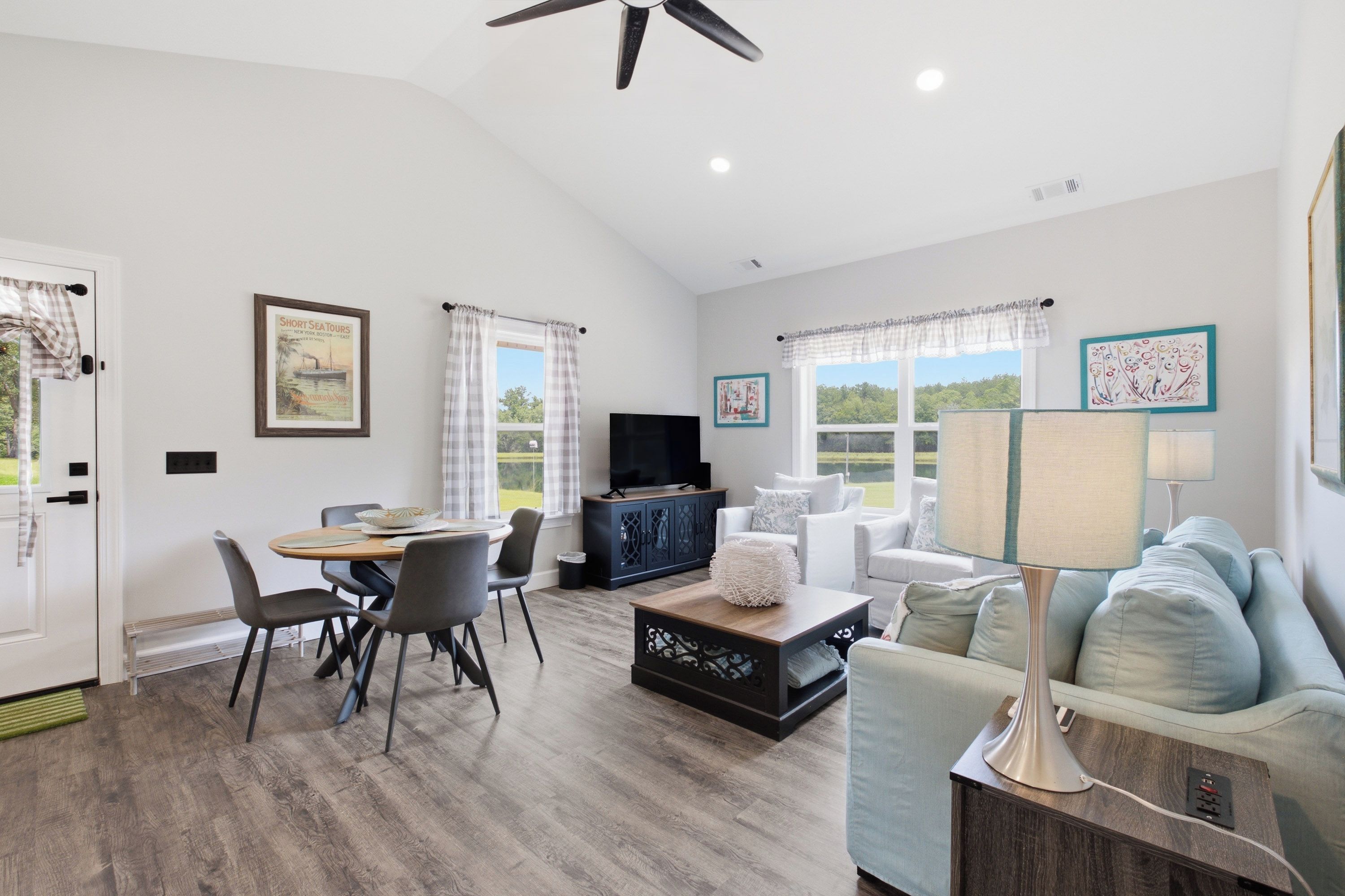 A spacious living room with a dining area, a television, and a sofa.