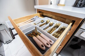 A drawer with compartments containing various kitchen utensils.