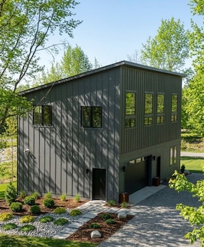 A modern two-story building with a flat roof, large windows, and a gravel driveway. - Fabulous 2-bedroom apartment in Traverse City-Monthly Rental (Traverse City)