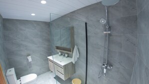 A modern bathroom with a glass shower enclosure, a white sink, and a large mirror. - Casa Maria - Affordable Luxury Rooms - Trochetia (Port Louis)