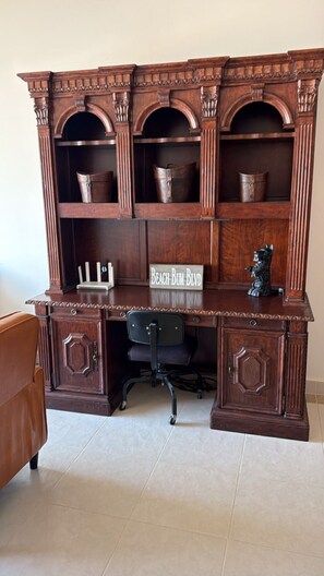 A wooden desk with a built-in bookshelf, a sign reading 'Beach Bum Blvd,' and a black office chair. - 3 Bdrm 3 Bath 1st Flr condo Mayan Lakes. Access to the Mayan Palace. Pets yes! (Mayan Lakes)