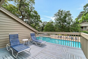 A wooden deck with blue lounge chairs and a pool. - Island Ease Villa Golf, Beach, Marina Nearby (Hilton Head Island)