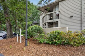 A two-story building with a balcony, a driveway, and a parking area. - Island Ease Villa Golf, Beach, Marina Nearby (Hilton Head Island)