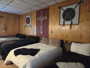 A room with two beds, wooden walls, and a cross on the wall. - Beautiful Viking "Long Hall" lodge with AC in charming Waubay SD. (Waubay)