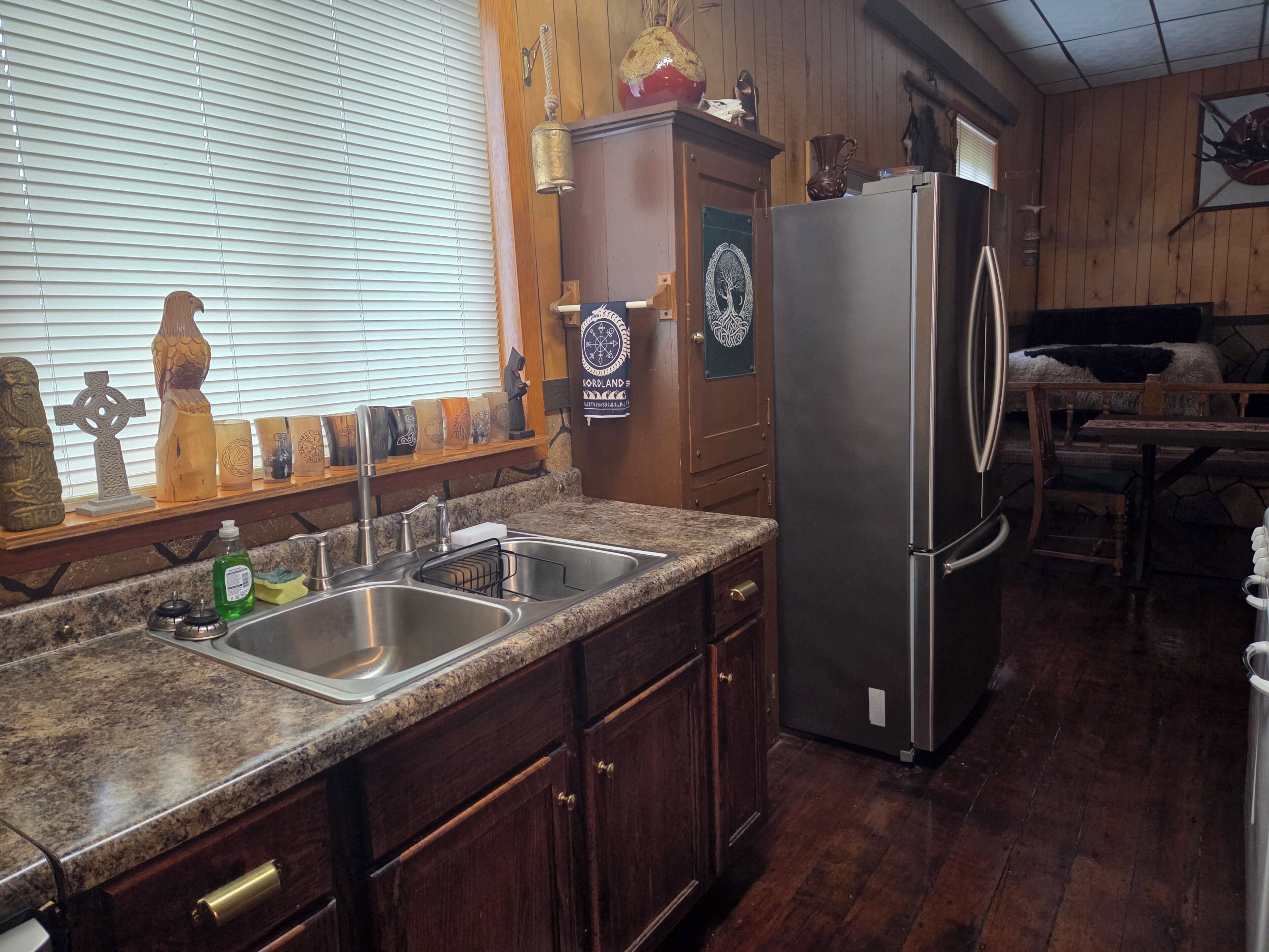 A kitchen with wooden cabinets, a stainless steel refrigerator, and a granite countertop.