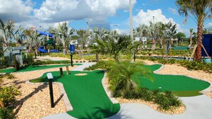 Un campo de golf con un fairway verde, búnkeres de arena y un obstáculo de agua.
