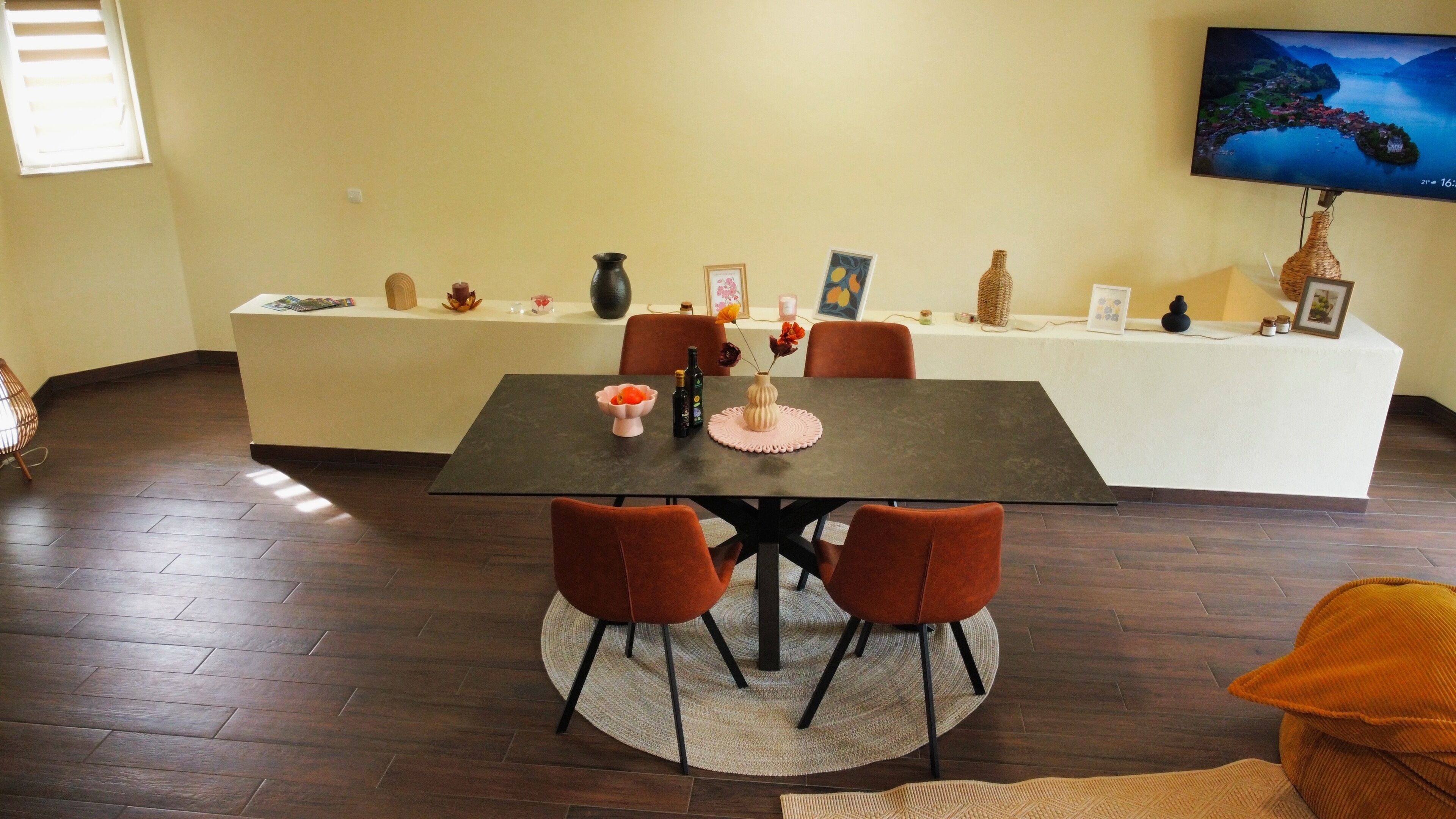 Un espace repas comprenant une table, des chaises et un téléviseur fixé au mur.