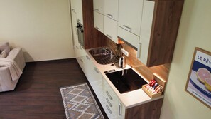 Eine kleine Küche mit Backofen, Spüle und einer Arbeitsplatte.