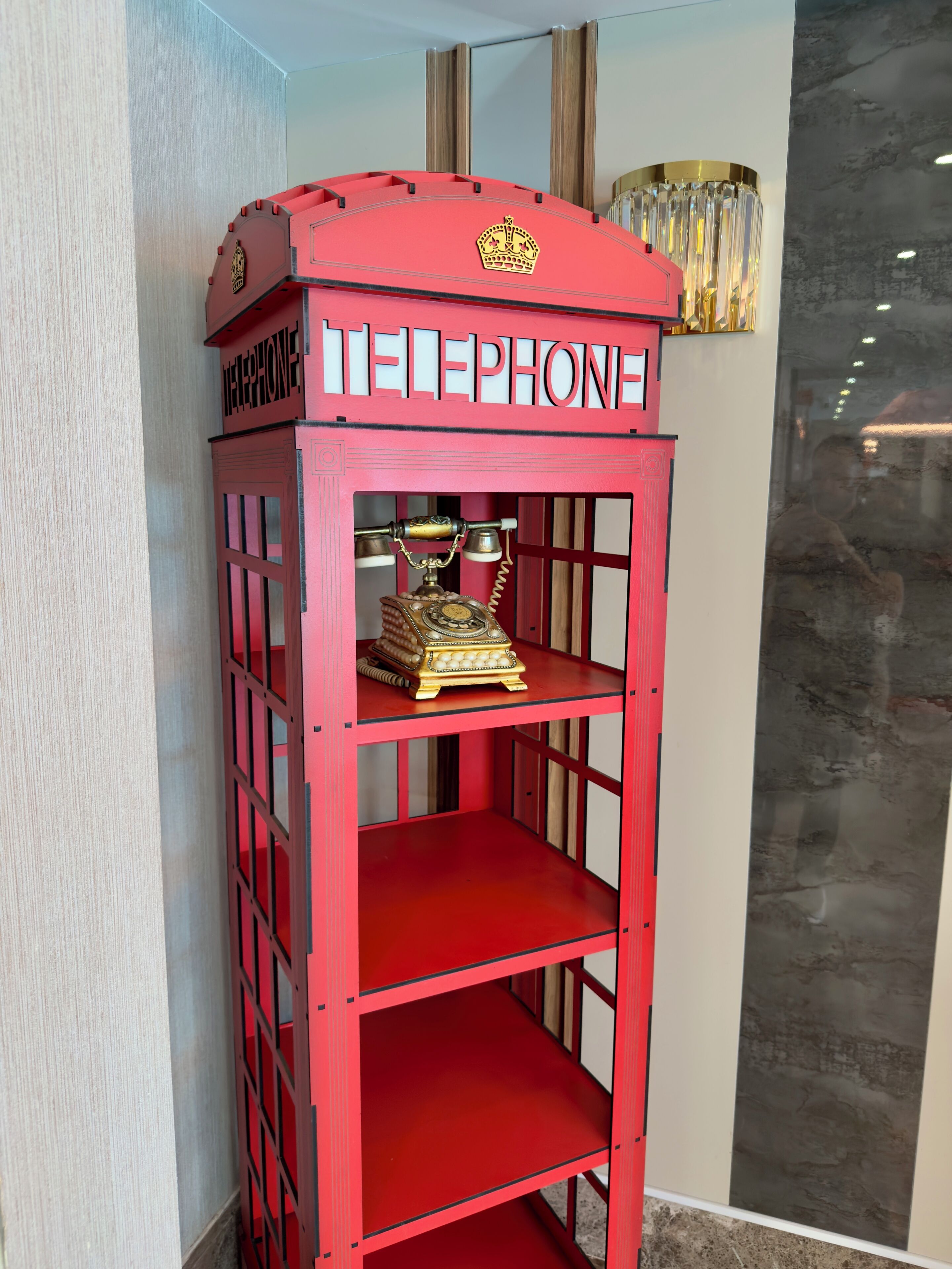 A red telephone booth with a crown emblem and the word 'TELEPHONE' on it.